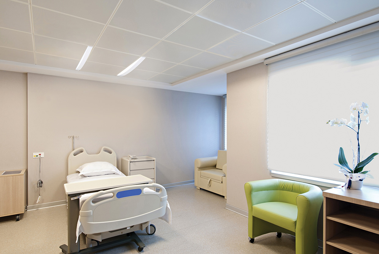 Unity overbed slot lights above patient bed in hospital room.
