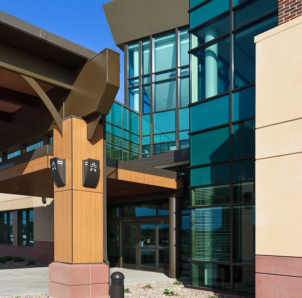 Cypress custom light fixtures in a commercial exterior with the logo laser-cut out of the luminaire body.